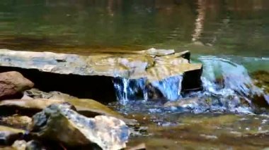 Video, bir dağ nehrinin parçaları. Taşların üzerindeki su akıntısı.
