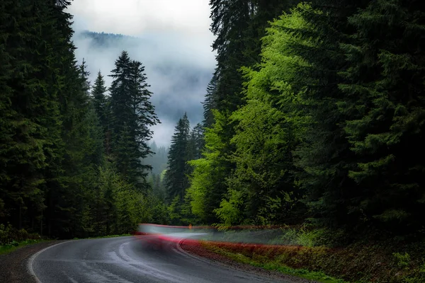 Dağlarda dolambaçlı bir yol. Yağmur yağarken dağlarda yol.