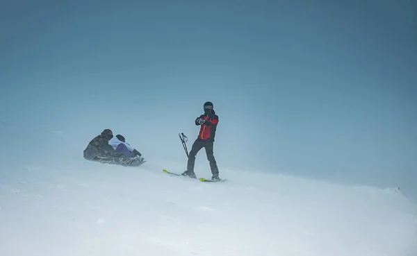 Kayakçılar ve snowboardcular dağdan inmeye hazırlanıyorlar..