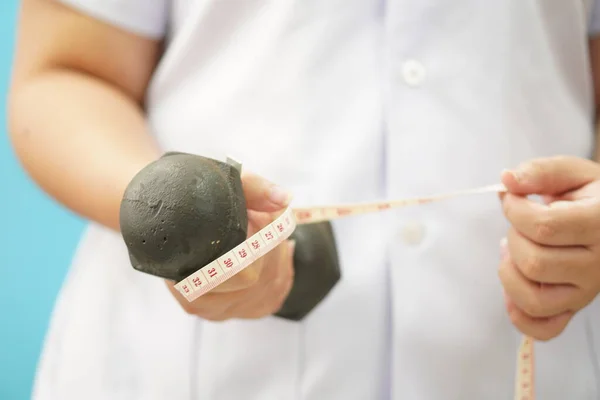 Medical: Close-up view of doctor with weight lifting dumbbells and waist tape, physical training background.