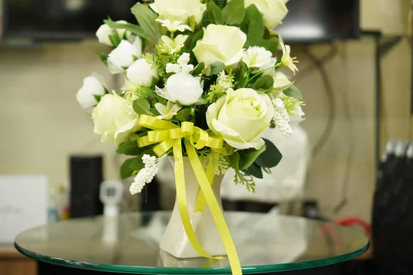 The picture shows a bouquet of paper flowers on the desk.