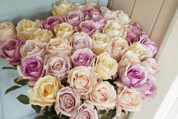 The picture shows a rose bush made of paper in a decorative vase in the living room.