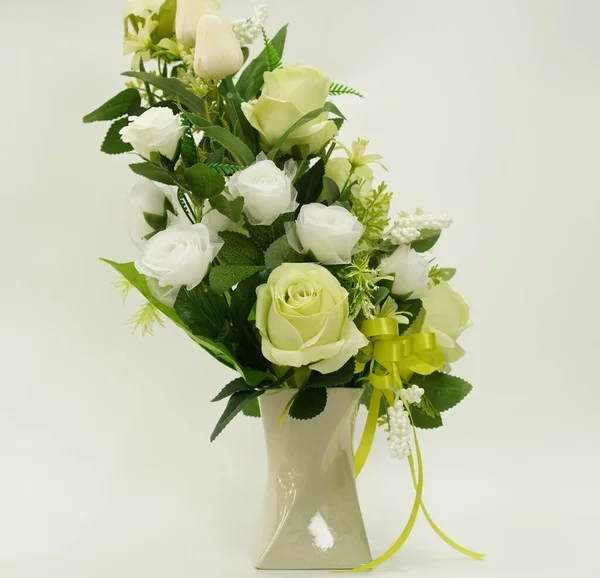 Picture of a bouquet of paper flowers in a vase for room decoration on a white background, isolated, close up.