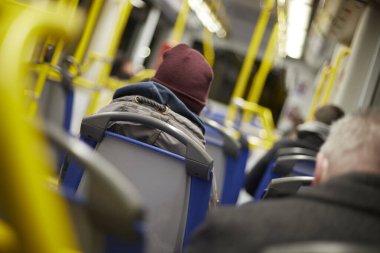 İnsanlar kış vakti metroda tramvayın içinde oturuyorlar.