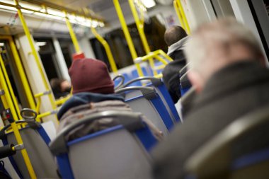 İnsanlar kış vakti metroda tramvayın içinde oturuyorlar.