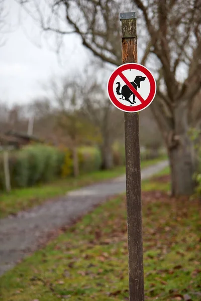 Sign in a park that dogs are not allowed to do their business here, no dog poo