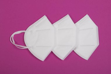 Kırmızı arka planda üç ffp2 maskesi. Covid-19 virüsüne karşı en iyi koruma maskesi.