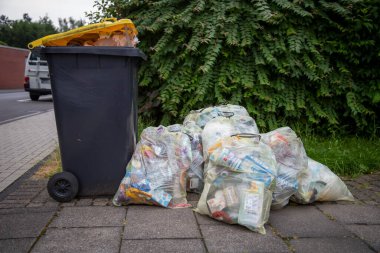 Huerth, NRW, Almanya, 06 23 2021, çöp tenekesi ve plastik çöp, sarı torbalara göre sıralanmış, çöp toplamaya hazır.