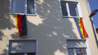 Huerth, NRW, Almanya, 06 26 2021, Alman bayrağı ve lgbtq bayrağı olan bir kasaba evinin ön cephesi