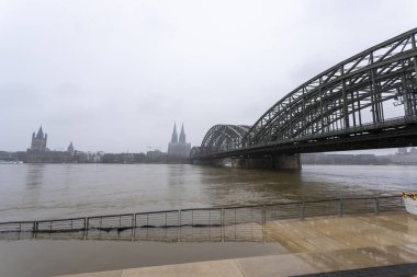 Köln 'ün karlı havalarda katedrali ve hohenzollern köprüsü olan panoraması. Ren nehri yüksek suyla