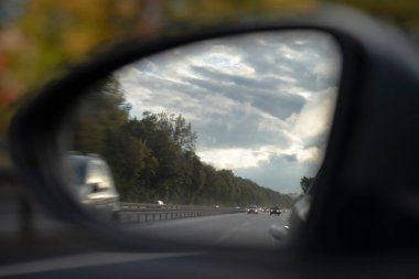 Higway 'deki bir arabanın arka aynasında. Farları açık arabalar.