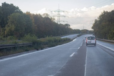Alman otoyolunun düşük trafiği, kırmızı arka ışıklar, arabalar, hareket bulanıklığı, ön taraftaki asfalta odaklan