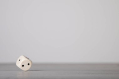 Zarlar düştü, gri tahta üzerinde beyaz bir zar.