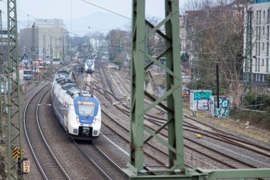 Bonn, NRW, Almanya, 03 23 2021, Bonn ana istasyonuna giden beyaz ve mavi tren. İstasyondan önce rayların görüntüsü