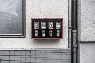 Bonn, NRW, Almanya, 03 23 23 2021, bir duvara yapıştırılmış sakız makinesi, kanalizasyon borusu ve camdaki yansımalar