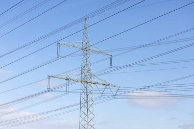 Güç kablosu olan güç direği, arkaplan olarak mavi gökyüzü, görünüm 