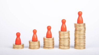 Başarıyı simgelemek için arka arkaya bir avroluk madeni para, kırmızı ahşap heykelcikler ve beyaz arka plan