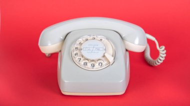 Eski gri telefon, arama plakalı, kırmızı arkaplan