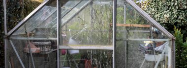 Bahçe bahçesindeki cam serada, ekipmanlar içinde.