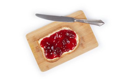 Çilek reçelli beyaz ekmek ve beyaz arka planda izole edilmiş gümüş bir bıçak.