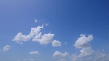Mavi gökyüzünde hareket eden beyaz bulutların hızlandırılmış 4K videosu