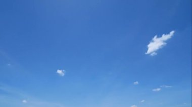 Mavi gökyüzünde hareket eden beyaz bulutların hızlandırılmış 4K videosu