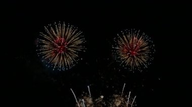 Kasvetli gece gökyüzünde parlayan 4k 'lık altın havai fişek videosu