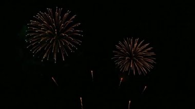 Karanlık gece gökyüzünde parlayan renkli havai fişeklerin 4K videosu