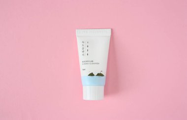 KYIV, UKRAINE - 19 AUGUST 2022: White skin care cream tube of South Korean brand Round lab. Dokdo cleanser with the sea water of Ulleungdo. Isolated on pink background. Top view.
