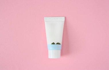 White plastic tube cosmetic mock up with screw cap. Wellness packaging. Cream tube, cleanser, mousse, lotion, shampoo. Skincare routine. Isolated on pink background. For design. Top view. Copy space.