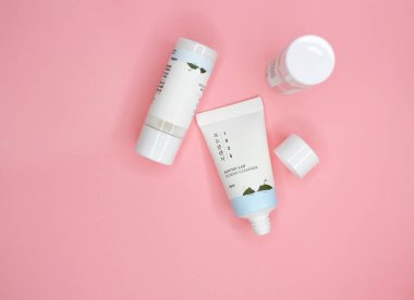 KYIV, UKRAINE - 19 AUGUST 2022: Flat lay set of travel size mini korean skin care products Round Lab, Dokdo tonic, cleanser and lotion. Pink background. Top view.