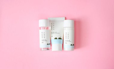 KYIV, UKRAINE - 19 AUGUST 2022: Mini set of korean cosmetics brand Round lab Dokdo tonic, cleanser and lotion. Isolated on pink background. Top view. Selective focus.