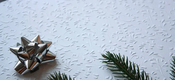 Weihnachten Hintergrund Mit Einzelnen Silbrig Glänzenden Geschenk Bogen Und Tannenzweig — Stockfoto