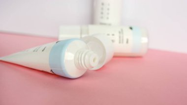 KYIV, UKRAINE - 19 AĞUSTOS 2022: Kore cilt bakımı marka mini ürün seti pembe ve beyaz arka planda tonik, temizleyici ve losyon. Yan görüş. Seçici odak.