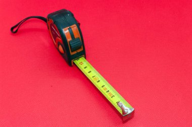 Sembol resmi ölçüsü: Metal mezurayı sar, kırmızı arkaplanda kes