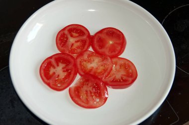 Vegetarian diet: thinly sliced tomatoes on a white plate