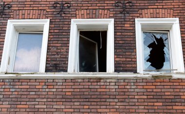 Sembolik görüntü: Terk edilmiş. boş, geçmiş, kırılmış: keçi tuğlalarından yapılmış ev cephesi, boş ve kırık pencere