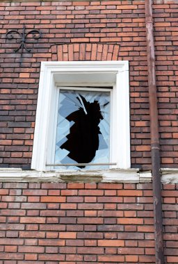 Sembolik görüntü: Terk edilmiş. boş, geçmiş, kırık: tuğla cephesinde tek bir kırık pencere