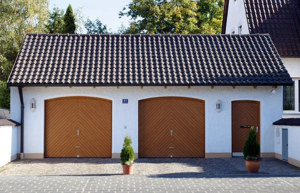 Parking in the city: bush in front of the gates of a double garage