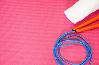 Kırmızı yoga minderinde ip ve havlunun üst görüntüsü. Fotokopi alanı ile sağlıklı konsept.