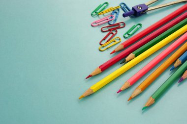 Okul malzemelerinin ve ofis malzemelerinin mavi arka planda üst görüntüsü. Öğrenim, öğrenim, ofis ekipmanları ve sunum konsepti.