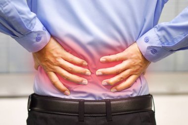 Business man wearing blue shirt feels back pain. Healthcare and medical concept.
