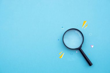 Magnifying glass on blue background in pastel colours. Minimal creative concept.