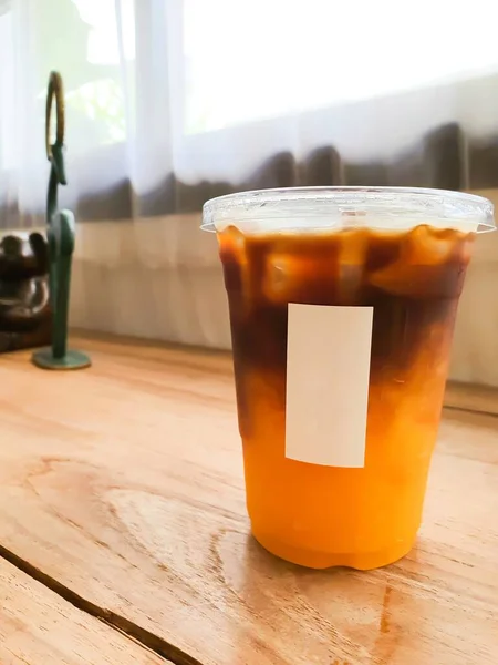 Portakallı kahve, portakal suyu ile buzlu kahve pencere kenarındaki ahşap masaya konur.