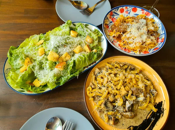 lunch time spaghetti and Cesar salad on table