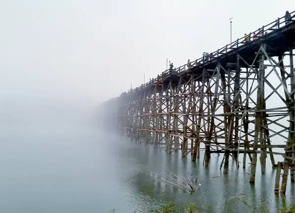 Nehri geçmek için tahta köprü. Sise doğru git.