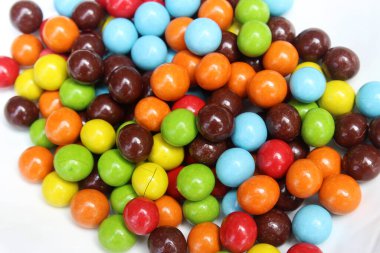 Beyaz arka planda lezzetli çikolata rengi şekerler