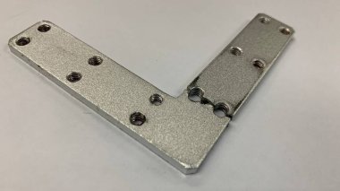 Gümüş renkli L plaka parçacığı hasarlı.