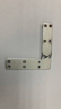 Gümüş renkli L plaka parçacığı hasarlı.