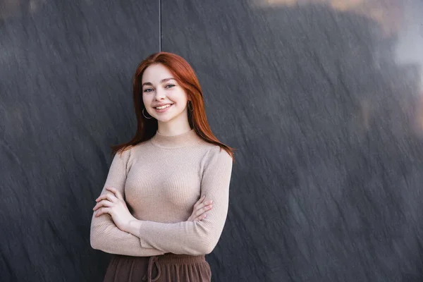 Glad Rödhårig Kvinna Beige Polotröja Står Med Korsade Armar Nära — Stockfoto